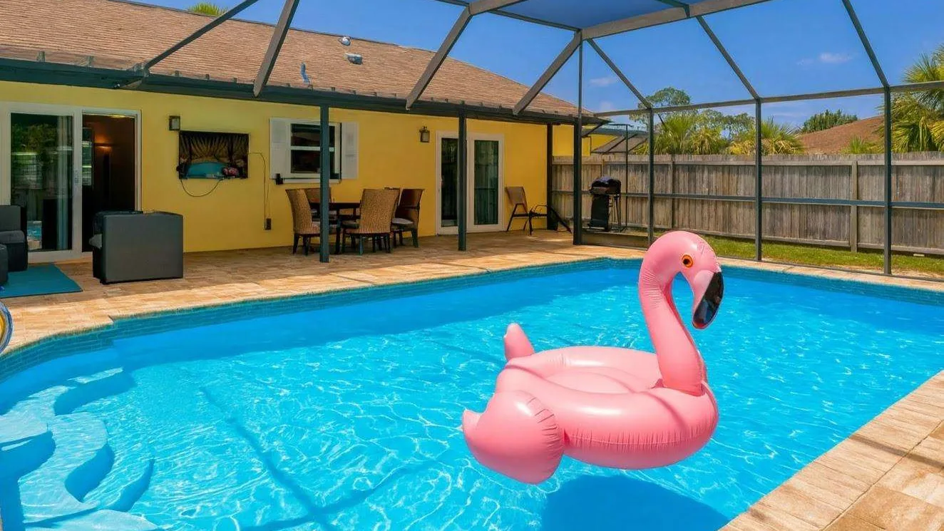 Screened pool with a pink flamingo float at the pool home at 4212 1st Ave W in Bradenton